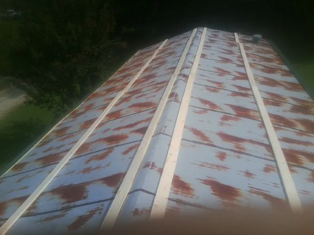 Rusted metal roof panels with new wood purlins before replacement — Storm Damage Roof Repair in Chatham by Roofing Brothers