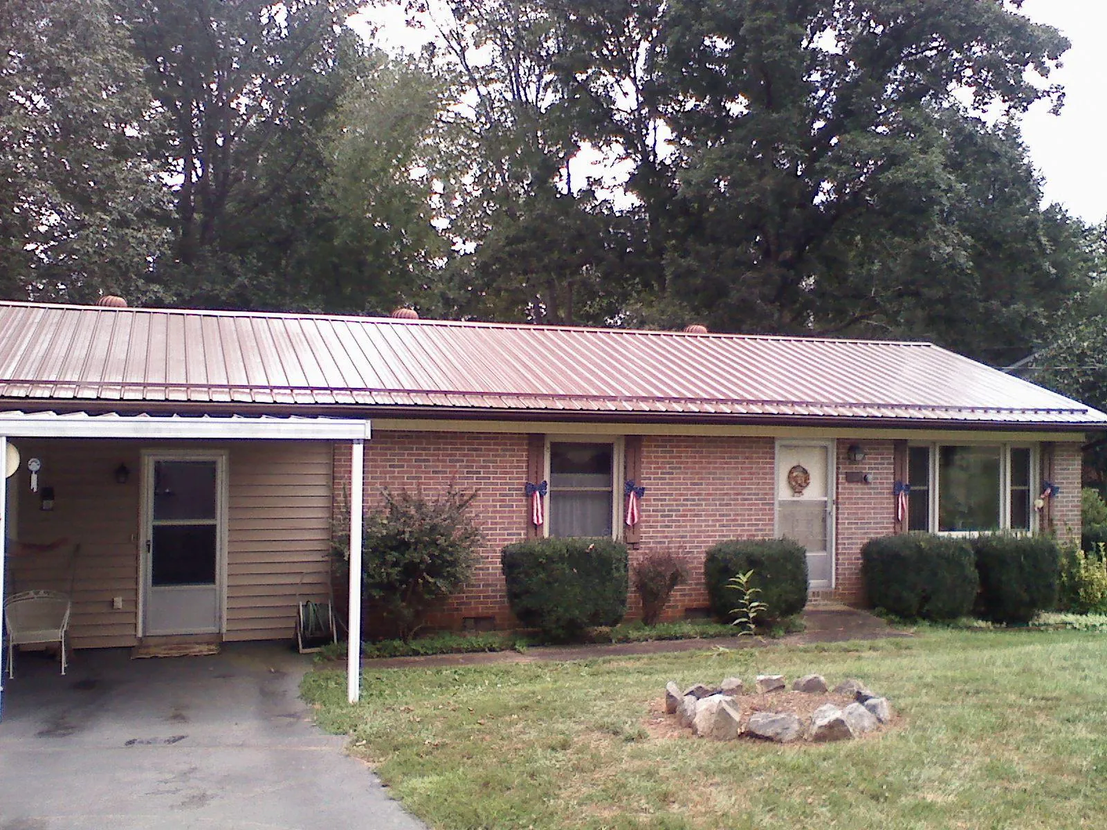 Bronze metal roof and carport on a brick ranch home — Roof Repair work by our crew in Chatham